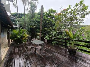 a patio with a table and chairs on a wooden deck at "Cantinho das serestas" em flats com piscina, sem café in Conservatória
