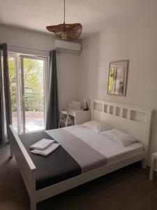 a bedroom with a bed and a large window at Quattro Rocce Apartments Zelen in Sutomore