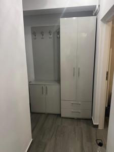 a white closet with white cabinets and a wooden floor at Otopeni Maramures in Otopeni
