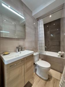 a bathroom with a toilet and a sink and a tub at La suite de Elise in Beaulieu-sur-Mer