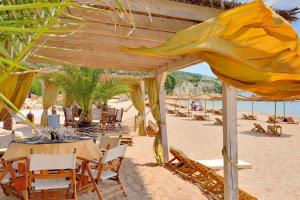 ein Restaurant am Strand mit Tischen und Stühlen in der Unterkunft Thracian Cliffs Golf & Beach Resort in Kawarna