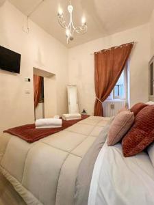 a large bedroom with two large beds and a chandelier at Palazzo Monterone Apartments in Spoleto
