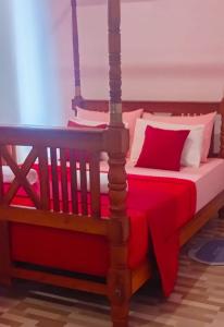 a bedroom with a bed with red and white pillows at Holiday Home Ragama in Ragama