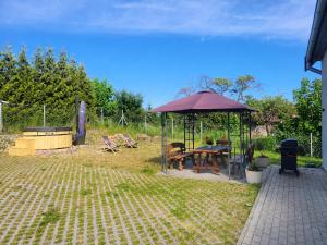 a gazebo with a picnic table in a yard at Apartament Harsz in Harsz