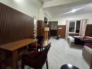 a hotel room with a table and chairs and a bed at LHO-Men RESIDENCY in Gangtok