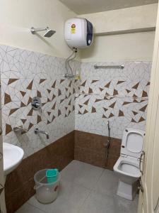 a bathroom with a toilet and a sink at LHO-Men RESIDENCY in Gangtok