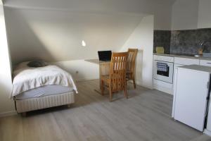 a bedroom with a bed and a desk with a laptop at My Pension City Großaitingen - Augsburg in Großaitingen
