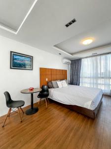 a bedroom with a bed and a table and chairs at The Hermitage Tagaytay-Presidential Suite in Malabag