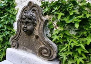 a statue of a head on the side of a wall at Ferien im Kellisch-Haus in Schalkenmehren