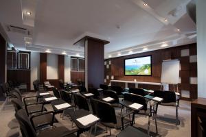 a conference room with tables and chairs and a projection screen at Thracian Cliffs Golf & Beach Resort in Kavarna +75 photos