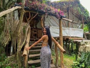 a woman standing in front of a small house at Bio Hotel - Eco Glamping El Refugio in Gigante +3 photos