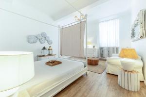 a white bedroom with a bed and a window at Piazza di Spagna Historic Flat in Rome