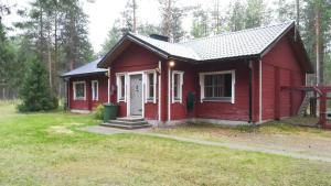 a red tiny house in the middle of a yard at Poropelto Cottage in Ruhtinaansalmi