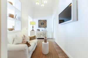 a living room with a white couch and a tv at Piazza di Spagna Historic Flat in Rome