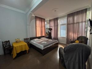 a bedroom with a bed and a table and a window at Twins Kobuleti in Kobuleti