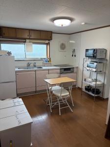 a kitchen with a table and a table and chairs at KAMIKURA stay in Shingū