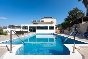 a swimming pool in front of a house at Apartments Rajsko Mjesto in Tivat
