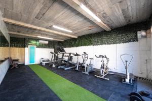 a gym with treadmills and exercise equipment on the wall at Apartments Rajsko Mjesto in Tivat