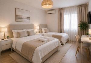 a bedroom with two beds and a table and a desk at Hostal Palma Hermosa in El Puerto de Santa María