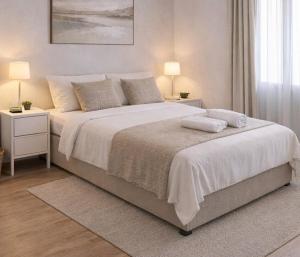 a white bedroom with a large bed with two night stands at Hostal Palma Hermosa in El Puerto de Santa María