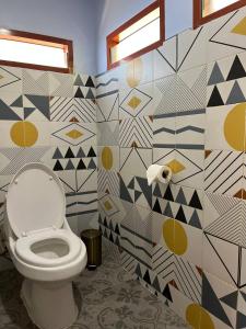 a bathroom with a toilet and a geometric wall at Amber Koh Rong in Koh Rong Island +26 photos