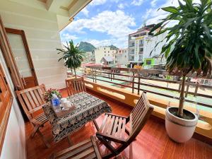 a balcony with a table and chairs and a plant at Hoa Phuong Hotel Phong Nha in Phong Nha