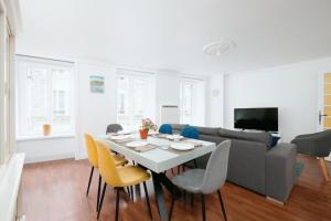 a living room with a table and yellow chairs at Le Triplex du Vœu Spacious Apartment in Cherbourg en Cotentin