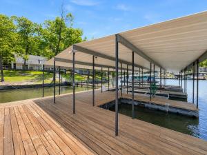 a dock with a large building on the water at The Ozark Acre 6BDR Lakefront in Sunrise Beach