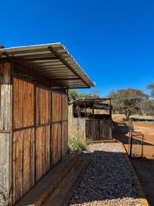 a wooden building with a gate and a fence at Glocke Mountain Camp, Cabin in Outjo +10 photos