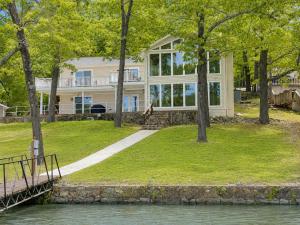 a house on the shore of a body of water at The Ozark Acre 6BDR Lakefront in Sunrise Beach
