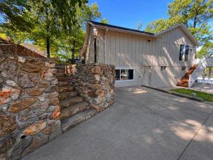 a stone retaining wall in front of a house at The Ozark Acre 6BDR Lakefront in Sunrise Beach
