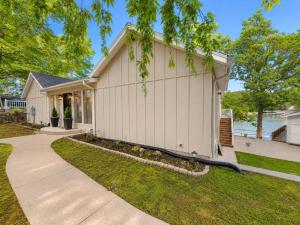 a white house with a tree in front of it at The Ozark Acre 6BDR Lakefront in Sunrise Beach +42 photos