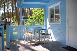 a blue house with a table and chairs on a patio at Greckie Domki ZEUS in Stegna