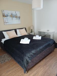 a bedroom with a large bed with two towels on it at Apartman Ines in Pribislavec