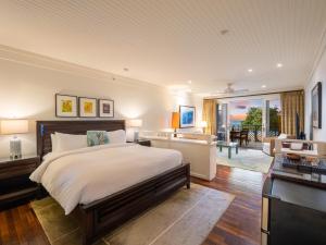a bedroom with a large bed and a living room at Villa 202 at Turtle Bay in Kahuku +42 photos