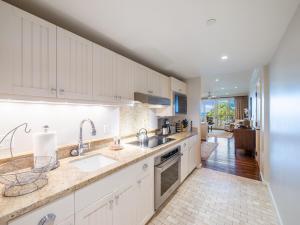 a kitchen with white cabinets and a sink at Villa 202 at Turtle Bay in Kahuku