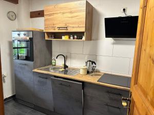 a small kitchen with a sink and a refrigerator at Tiny House mit Terrasse nahe dem Bodensee in Wahlwies