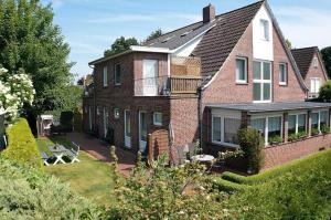 a large brick house with a balcony and a yard at Pension Murra in Stedesdorf