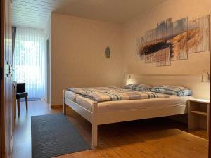 a bedroom with a bed and a desk and a window at Pension Murra in Stedesdorf