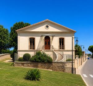 a white house with a fence in front of it at LE PALMIER Aigues-Mortes Petite Camargue in Aigues-Mortes