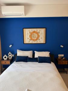 a bedroom with a blue wall with a bed at Karen's Favorite in Skala Potamias