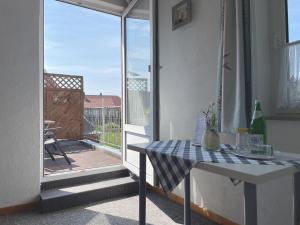 a room with a table and a balcony with a view at Pension Murra in Stedesdorf