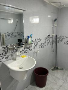 a white bathroom with a sink and a shower at Velu House - 2-Room Apartment in Jaffna