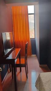 a room with a desk and a window with a laptop at Hotel Venecia ll in Huánuco