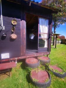 a small shed with a porch and some tires around it at Wagon Wheel Gabin in Chrissiesmeer