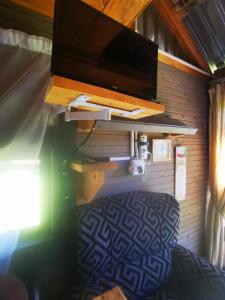 a room with a tv and a bed in a house at Wagon Wheel Gabin in Chrissiesmeer