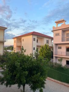 a row of apartment buildings with a tree in the foreground at Infinity room in Velipojë