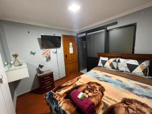 ein Schlafzimmer mit einem Bett, auf dem ein Löwe abgebildet ist in der Unterkunft Departamentos en Cuenca in Cuenca