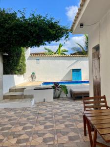 a patio with a bench and a building at Renascer Suites in Búzios