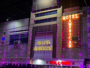 a hotel with neon signs in front of a building at Hotel American in Sahāranpur